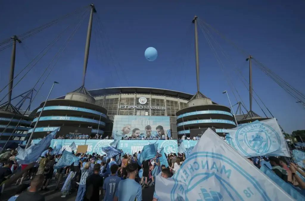 Man City Premier League charges: An exterior view of the Etihad Stadium with Manchester City fans gathered outside.
